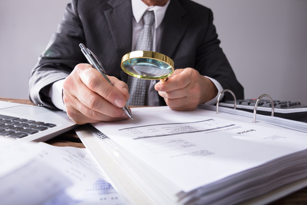 man at desk holding binder